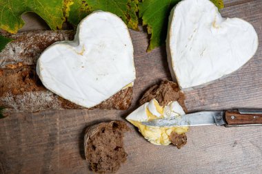 Tahta arka planda Fransız Neufchatel peyniri şeklinde bir kalp.