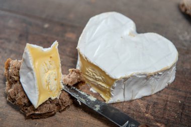 Fransız Neufchatel peyniri ahşap arka planda kalp şeklinde.