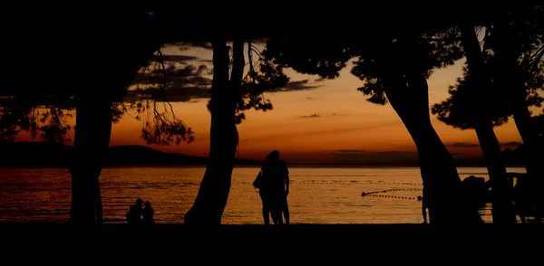 日落时分在海滩上的人 — 图库照片