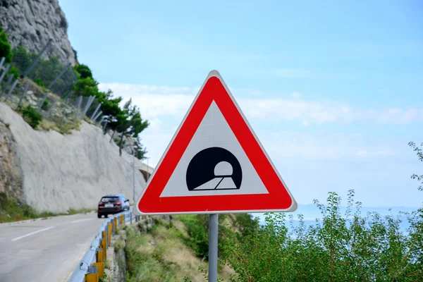 Vägmärke tillkännage en tunnel i bergen — Stockfoto