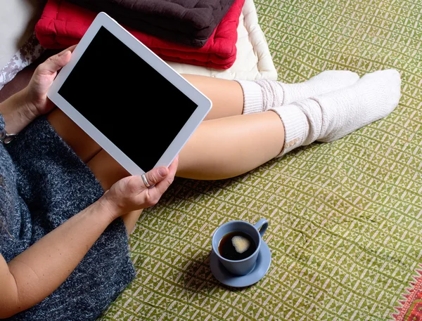 Digitales Tablet auf den Beinen einer jungen Frau — Stockfoto