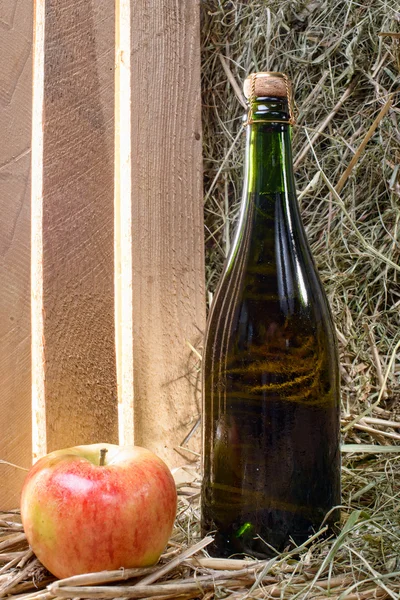 Бутылка сидра с яблоком и соломой — стоковое фото