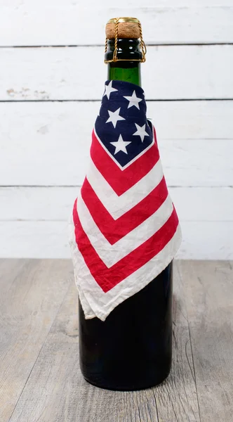 Garrafa de cerveja cercada com uma bandeira americana — Fotografia de Stock