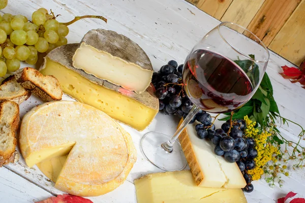 Savoie διαφορετικά τυριά με ένα ποτήρι κόκκινο κρασί — Φωτογραφία Αρχείου