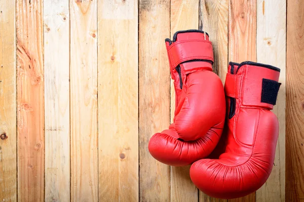 Pair of red boxing gloves hanging on the wall — Stock Photo, Image