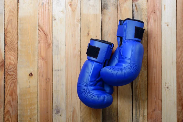 Paar van blauwe bokshandschoenen opknoping op de muur — Stockfoto