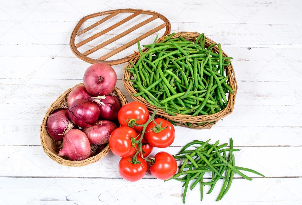 Basket of green beans with tomatoes and onions Stock Photo by