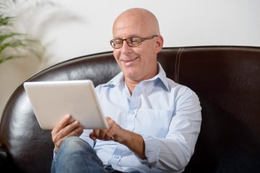 Gözlüklü bir üst düzey bir dijital tablet vasıl görünüyor