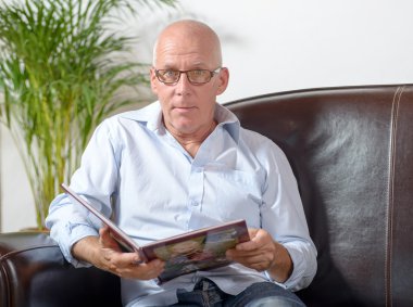 bir adam bir kanepenin üzerine bir kitap okuma