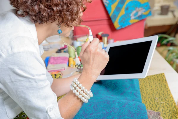 Dressmaker mira una tableta digital en su taller — Foto de Stock