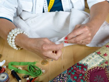 Bir kadın bir gömlek üzerinde bir düğme diker