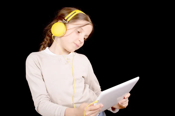 Una joven con auriculares y una tableta digital —  Fotos de Stock