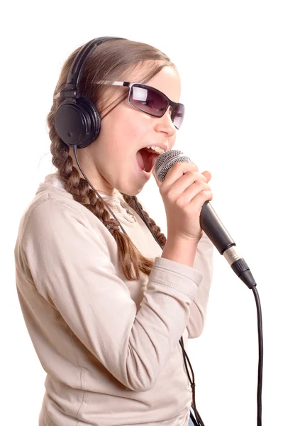 Молодая девушка в наушниках поет с микрофоном — стоковое фото