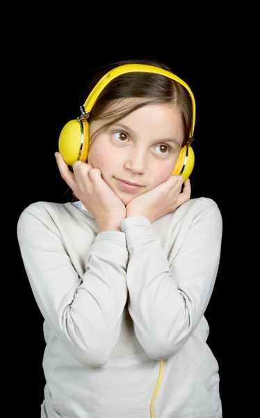 Krásná mladá dívka poslouchá hudbu se sluchátky — Stock fotografie