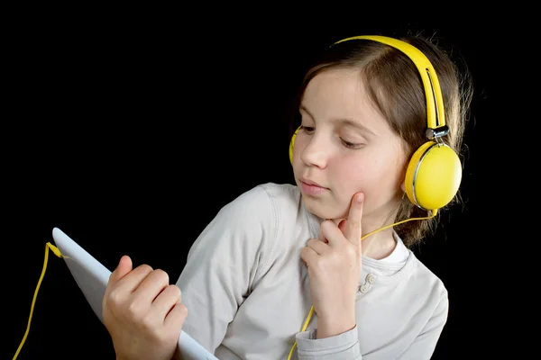 Una hermosa joven escuchando música con una tableta digital —  Fotos de Stock