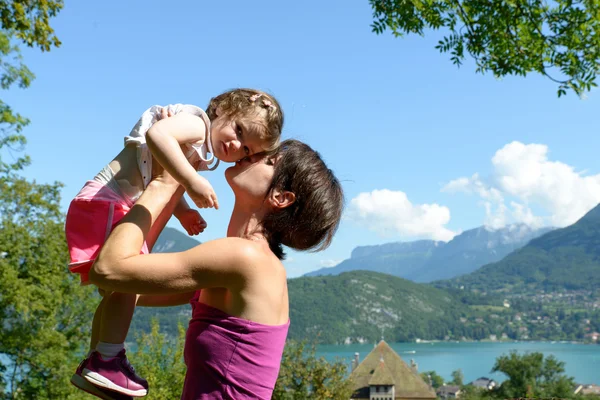 Eine schöne Mutter ist eine Umarmung für ihre Tochter in der Natur — Stockfoto