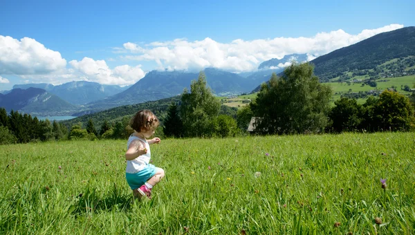 Mała dziewczynka gra na łące — Zdjęcie stockowe