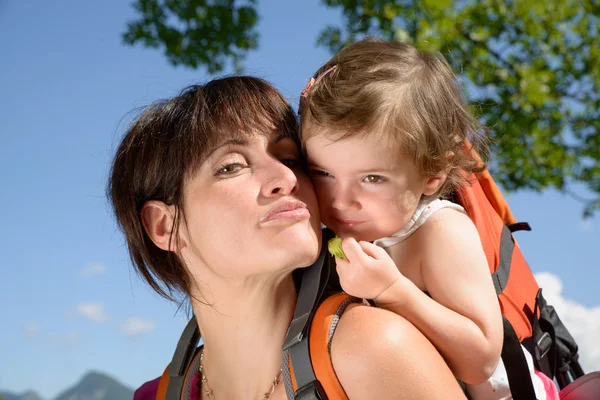 En vacker mamma är en kram till sin dotter i naturen — Stockfoto