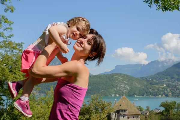 Una hermosa madre es un abrazo a su hija en la naturaleza —  Fotos de Stock