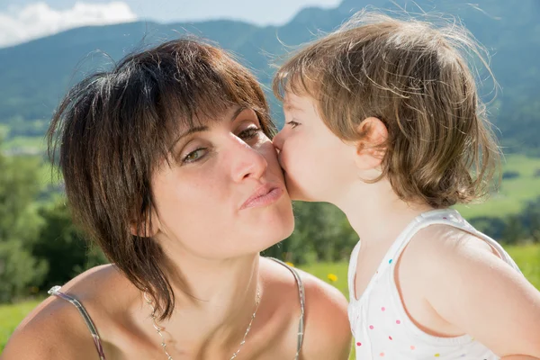 Eine schöne Mutter ist eine Umarmung für ihre Tochter in der Natur — Stockfoto