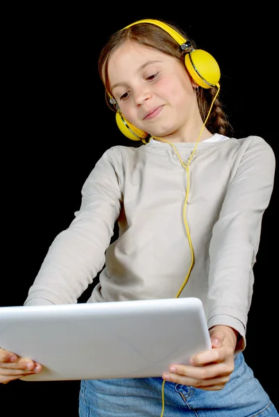 Una hermosa joven escuchando música con una tableta digital —  Fotos de Stock