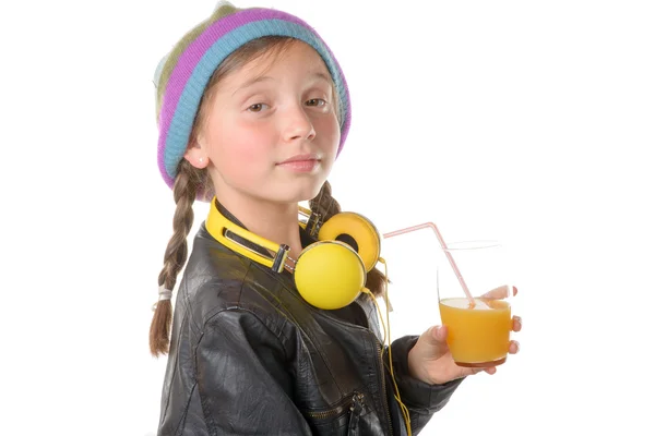 A pretty little girl with a woolen cap drinking a glass of orang — Stock Photo, Image