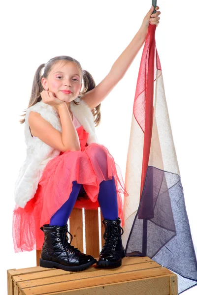 Una niña bonita sentada en una caja con una bandera francesa —  Fotos de Stock