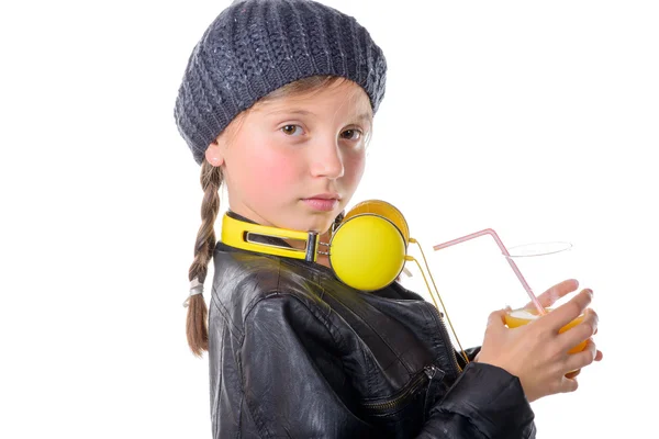 Une jolie petite fille avec une casquette en laine buvant un verre d'orang — Photo