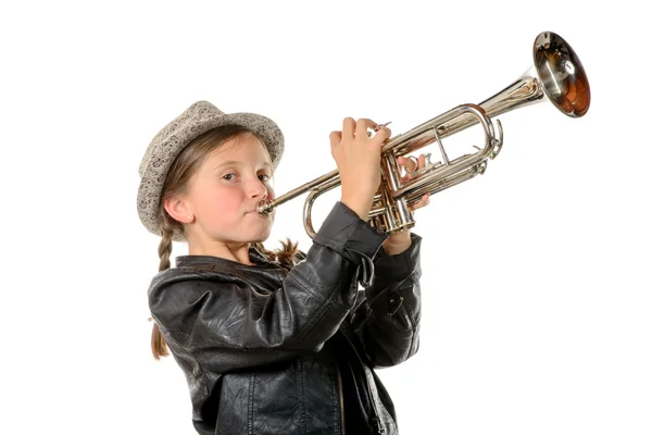 A pretty little girl with a black jacket plays the trumpet — Stock Photo, Image