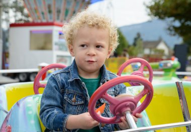 bir eğlence Fuarı atlıkarınca oynayan küçük bir çocuk