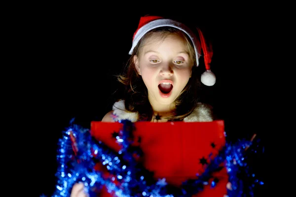 Una niña bonita abre su regalo de Navidad — Foto de Stock