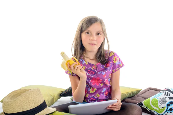 Girl with a digital tablet and banana in his hand — Stock Photo, Image