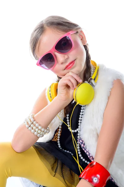 A pretty little girl with pink glasses and yellow headphones — Stock Photo, Image