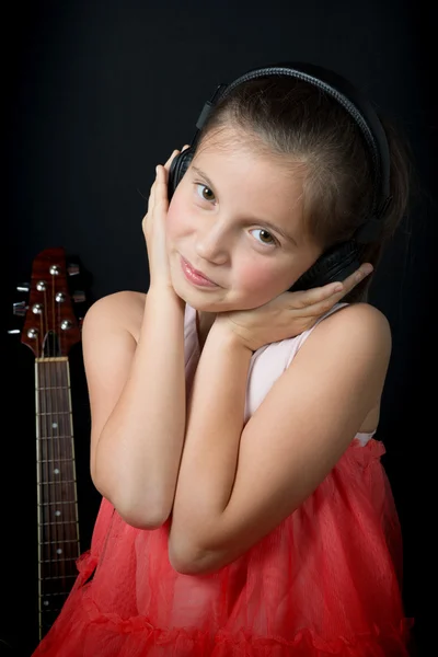 Una linda niña escuchando música con auriculares — Foto de Stock