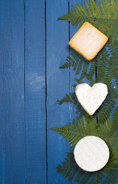 Verschiedene französische Käsesorten auf blauem Holztisch — Stockfoto