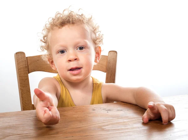 Pequena criança loira sentada à mesa — Fotografia de Stock