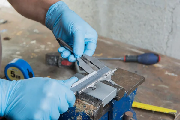 En mekaniker med blå handskar och en vernier bromsok — Stockfoto