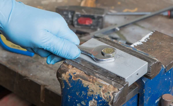 Werknemer is geschroefd een moer met een moersleutel — Stockfoto