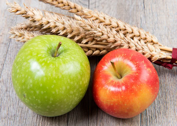 Appels en tarwe cobs geplaatst op een houten tafel — Stockfoto