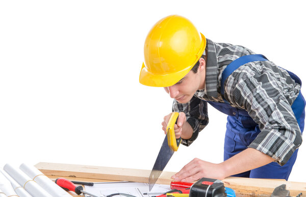 рабочий ручной пилой спилил доску из дерева
