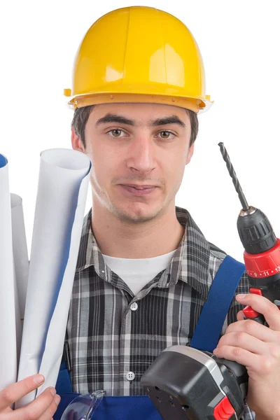 Un joven trabajador con un taladro y planes — Foto de Stock