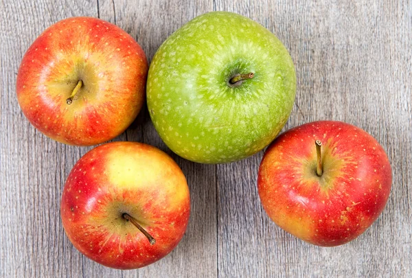 Grüne und rote Äpfel auf einem Holztisch — Stockfoto