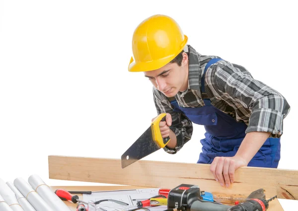 Ein Arbeiter schnitt mit der Handsäge ein Holzbrett — Stockfoto