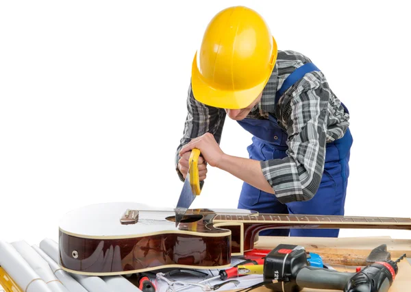 Mladý dělník hraje hudbu s pilou a kytara — Stock fotografie