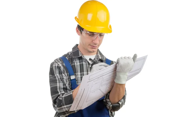 Young worker reads a plan — Stock Photo, Image