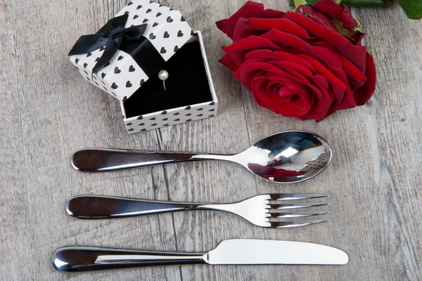 Cubiertos, rosa y regalo para el día de San Valentín — Foto de Stock