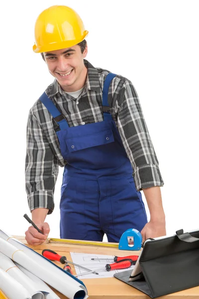 Ein Arbeiter, der ein Brett mit einem Maßband misst — Stockfoto