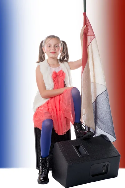 A pretty little girl sitting on a loudspeaker with a french flag — Stock Photo, Image