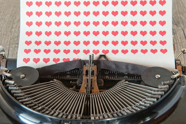 Old typewriter with red hearts on paper — Stock Photo, Image