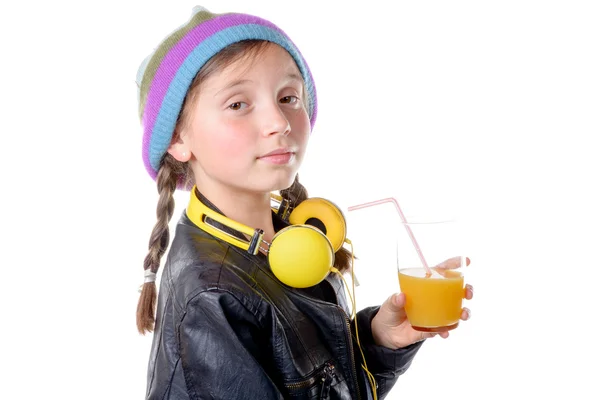 Una bella bambina con un berretto di lana che beve un bicchiere di orang — Foto Stock